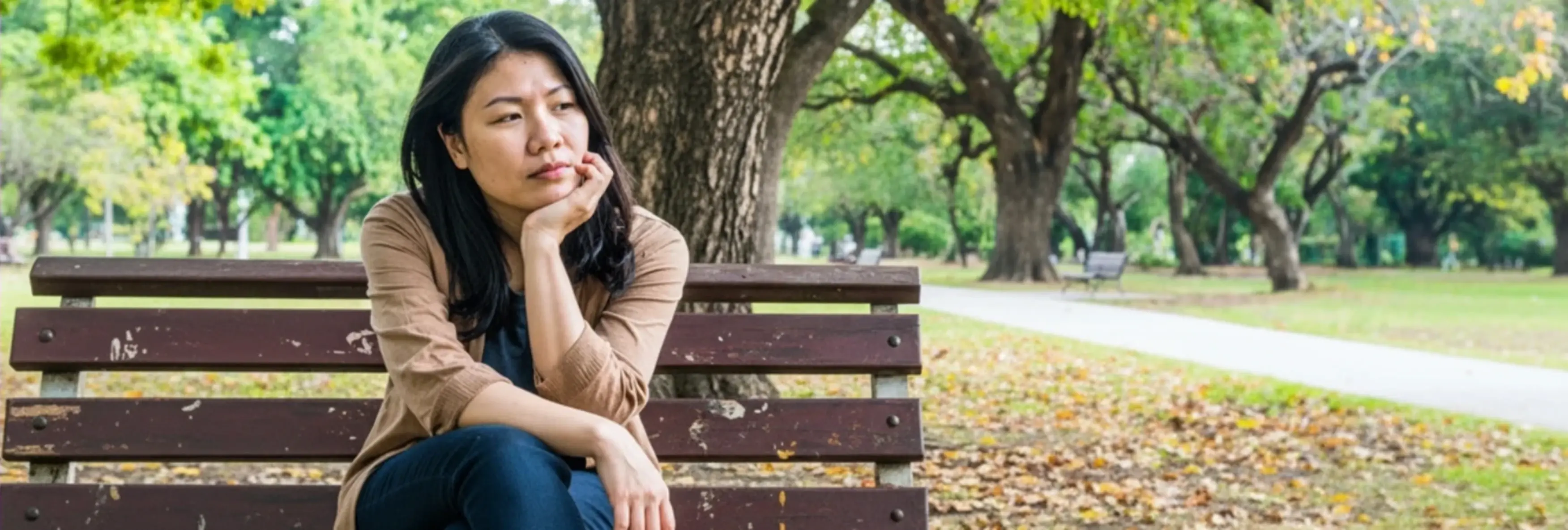 Medizinisches Informationsbild zum Thema Leben mit Immunthrombozytopenie (ITP). Das Bild zeigt eine Patientin in einer herbstlichen Parkumgebung und vermittelt die emotionale und kontemplative Dimension des Lebens mit einer chronischen Erkrankung.