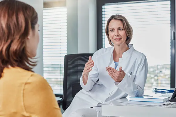 Professionnelle de santé en blouse blanche consultant une patiente dans un cabinet médical