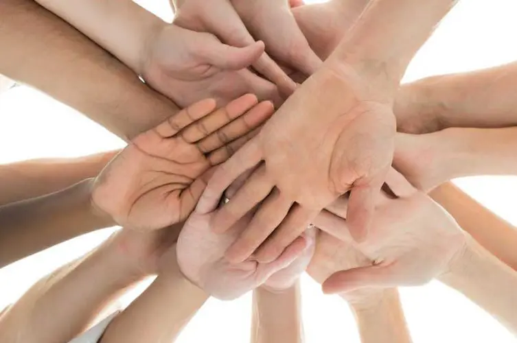 Hände im Kreis vereint, die Zusammenarbeit und Solidarität symbolisieren