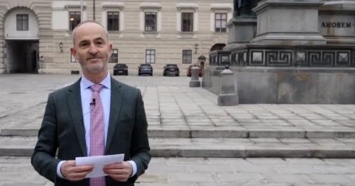 Diabetesfortbildung: Ein Mann in Anzug und mit Krawatte steht selbstbewußt vor der Klinik Favoriten Wien und erläutert einen Fall.