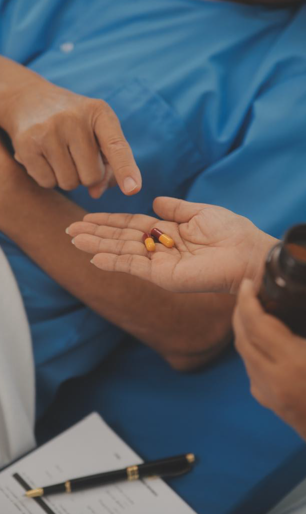 Nhân viên y tế đưa thuốc viên nang và lọ thuốc cho bệnh nhân trong buổi tư vấn lâm sàng